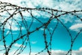 Barbed wire. Barbed wire on blue sky background with white clouds. Wire boom. Military conflict . Syria. Royalty Free Stock Photo