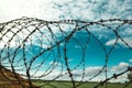 Barbed wire. Barbed wire on blue sky background with white clouds. Wire boom. Military conflict . Syria. Royalty Free Stock Photo