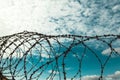 Barbed wire. Barbed wire on blue sky background with white clouds. Wire boom. Military conflict . Syria. Royalty Free Stock Photo