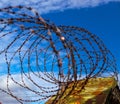 Prison. Barbed wire. Barbed wire on blue sky background with white clouds. Wire boom. Military conflict . Syria. Royalty Free Stock Photo