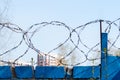 Barbed wire on a blurred background of a fragment of residential buildings. Concept of isolation. Selective focus Royalty Free Stock Photo