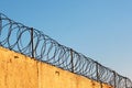 Barbed wire on concrete fence against blue sky background Royalty Free Stock Photo