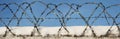 Barbed wire on a concrete wall. Panorama. Royalty Free Stock Photo