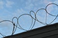 Barbed wire on the fence against the blue sky Royalty Free Stock Photo