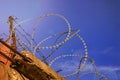 Barbed wire on the fence against the sky and the sun Royalty Free Stock Photo