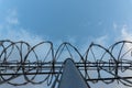 Barbed wire fence with bright blue sky to feel silent and lonely and want freedom. Dramatic clouds behind barbed wire fence on a Royalty Free Stock Photo