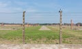 The barbed wire fence and the destroyed barracks in concentration camp Auschwitz II - Birkenau, Poland.