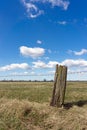 A barbed wire fence with old rustic wooden post Royalty Free Stock Photo