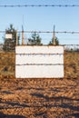 Barbed wire fence protects the danger zone. White sign board