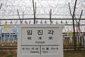 Barbed wire fence separates South from North Korea - South Korean flags attached to fence - Asia - SIGN POINTS TO GAESEONG AND SEO