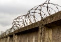 Barbed wire fence and stone wall Royalty Free Stock Photo