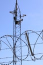 Barbed wire fence and surveillance cameras provide security - blue sky background with copy space Royalty Free Stock Photo
