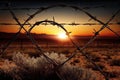 barbed-wire fence with a view of the sunrise over the horizon Royalty Free Stock Photo