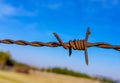 Barbed wire in foreground with blue background sky Royalty Free Stock Photo