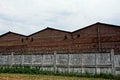 Barbed wire on a gray concrete fence along iron buildings Royalty Free Stock Photo