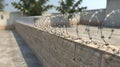 Barbed wire installation atop secure concrete fence for enhanced perimeter protection Royalty Free Stock Photo