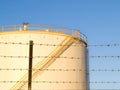 Barbed wire and Large circular fuel storage tanks