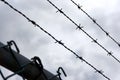 Barbed wire lines and fence against a dramatic dark cloudy Royalty Free Stock Photo