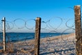 Barbed wire from metal on the beach wooden pillars blue sky summer sun Royalty Free Stock Photo