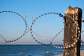 Barbed wire from metal on the beach wooden pillars blue sky summer sun Royalty Free Stock Photo