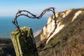 Barbed wire shaped into a heart with a back drop of white cliffs in Devon