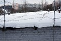 Barbed wire and snow on roof of old brick shed Royalty Free Stock Photo