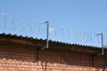 The barbed wire is tense over a brick wall Royalty Free Stock Photo