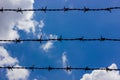 Barbed wires against blue sky