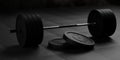 Barbell with chrome handle and black plates in front on floor on black mats background, sport, fitness, exercise or weightlift Royalty Free Stock Photo