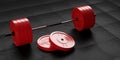 Barbell with chrome handle and red bumper plates in front on floor on black mats background, sport, fitness, exercise or weight
