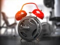 Barbell discs and alarm clock in gym. Time for workout gym concept