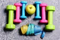 Barbells, colorful tape measures and apple placed in pattern, topview Royalty Free Stock Photo