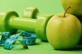 Barbells near juicy green apple. Dumbbells in bright green color Royalty Free Stock Photo