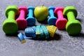 Barbells, tape measures and apple placed in pattern, close up Royalty Free Stock Photo