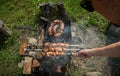 Barbeque meat and sausages or bratwurst on a grill grate in backyard. Man preparing shashlik or shish kebab over Royalty Free Stock Photo