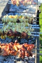 Barbeque meat and vegetable skewers cooked on fire in very long cafe grill outdoors, BBQ Royalty Free Stock Photo