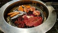 Barbeque with salmon, fish, pork, beef, sausage on stove at Korea restaurant.