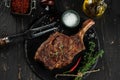 barbeque steak on a black slate board with meat fork on a dark background. top view. copy space for text Royalty Free Stock Photo