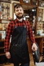 Barber in apron with cutting tools, barbershop