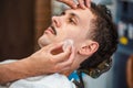 Barber closing mans pores with alum stone. Traditional ritual of after shaving the beard with alum stone. Client getting his face Royalty Free Stock Photo