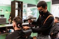 Barber combs and dries the hair of a customer in a barber shop Royalty Free Stock Photo