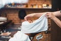 Barber covers the face of a man with a hot towel. Traditional ritual of shaving the beard with hot and cold compresses in a old