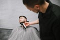 Barber cuts the barber shop`s beard clipper. Man deals with the correction of the beard in the men`s shop. Hairdresser does a Royalty Free Stock Photo