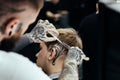 Tattooed Barber cuts the hair of the client with scissors. Close up. Attractive male is getting a modern haircut in Royalty Free Stock Photo