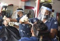 Barber cuts hair wearing protective shield