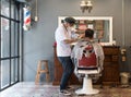 Barber cutting hair at a barber shop Royalty Free Stock Photo