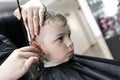 Barber cutting hair of a serious boy Royalty Free Stock Photo