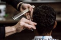 The barber is cutting a man`s hair holding scissors and comb in his hands opposite the mirror in a barbershop Royalty Free Stock Photo