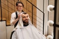 Barber dries the hair of the client with soft towel