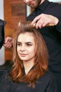 Barber dries the hair with the hair dryer of young, beautiful girl in a beauty salon Royalty Free Stock Photo